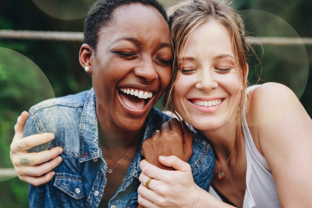 Two,Women,Laughing,And,Embracing.,Friendship,And,Joy.,Smiling,Women