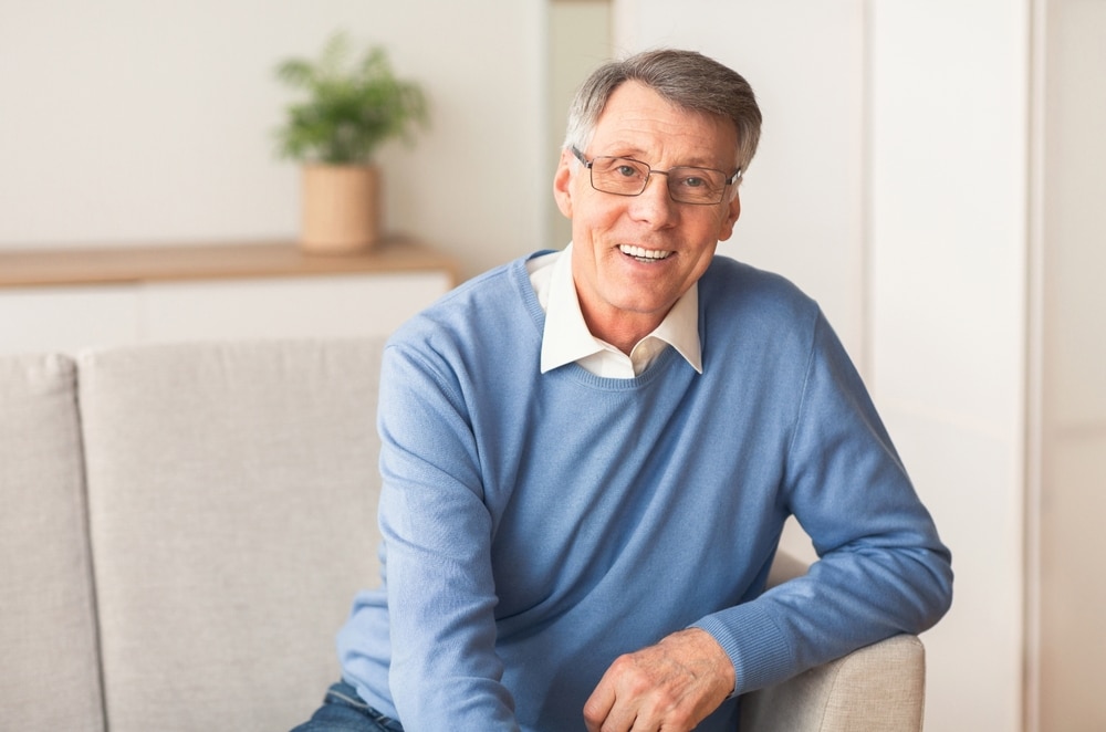 Elderly,Gentleman,Smiling,Sitting,On,Sofa,At,Home
