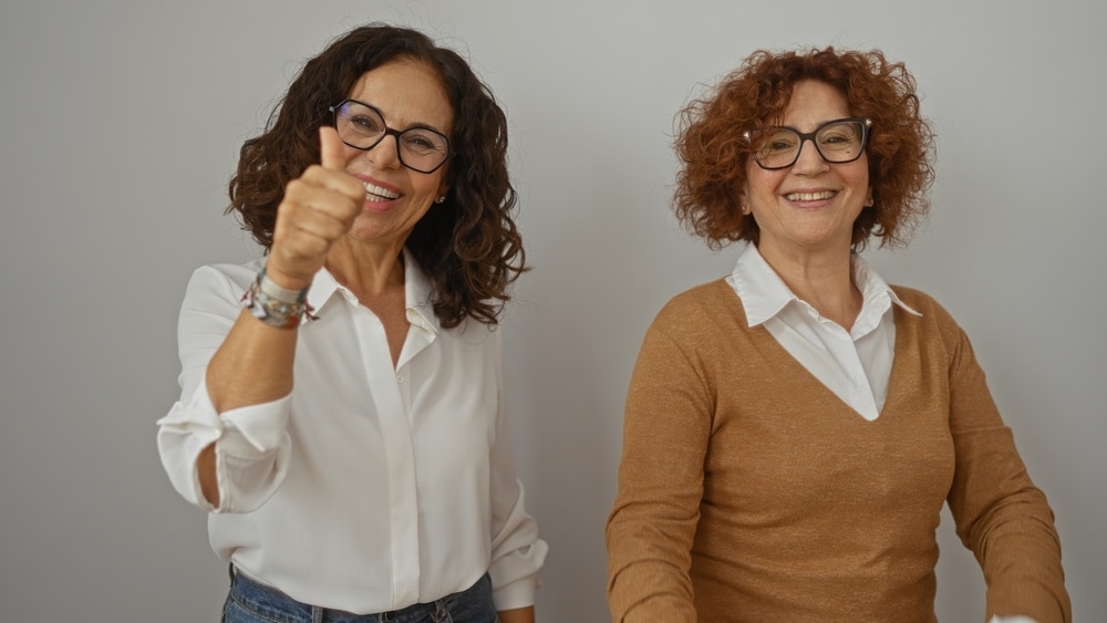 Two,Middle-aged,Hispanic,Women,Friends,Smiling,And,Showing,Thumbs,Up
