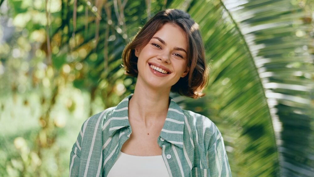 Smiling,Woman,Outdoors,In,Natural,Light,,Wearing,A,Striped,Green